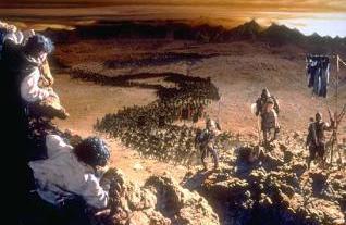 A painting shows Frodo and Sam peeking over a hill at an army of orcs.